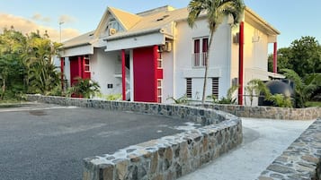 A two-story building with a stone retaining wall in front.