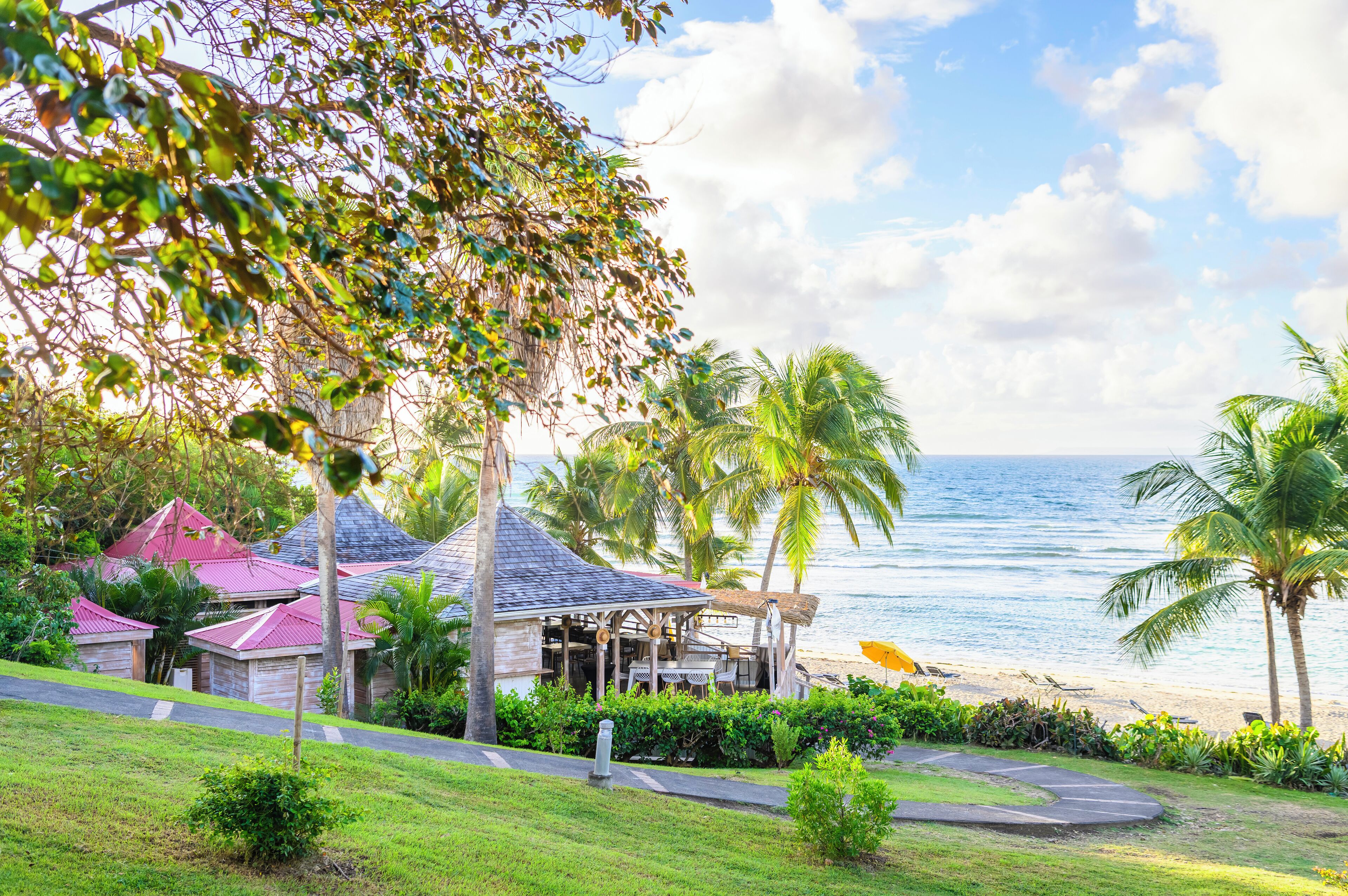 Praia particular, espreguiçadeiras, prática de vôlei de praia 
