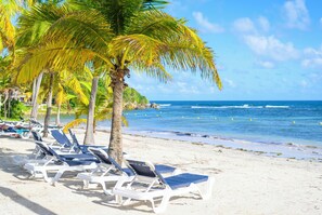 En privat strand, liggestole, volleyball, fiskeri