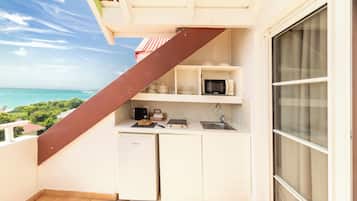 Une cuisine compacte équipée d’un four à micro-ondes, d’un évier et d’un petit réfrigérateur. Elle dispose également d’un balcon avec vue sur l’océan.
