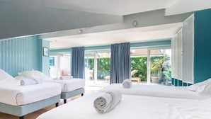 Ein Hotelzimmer mit zwei Betten, einem Balkon und Blick auf Grünflächen.