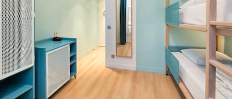 A room with bunk beds, a blue console table, and a mirror.