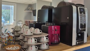 A coffee station with multiple coffee makers, a fan, and a variety of cups and containers. - Hotel Dom le Breton Nantes Beaujoire - Porte de Sainte Luce (Sainte-Luce-sur-Loire)