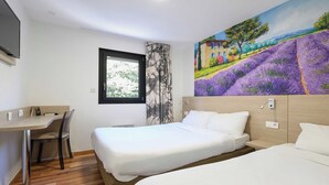 A hotel room with a bed, a desk, and a chair. - B&B HOTEL BOLLENE (Bollene)