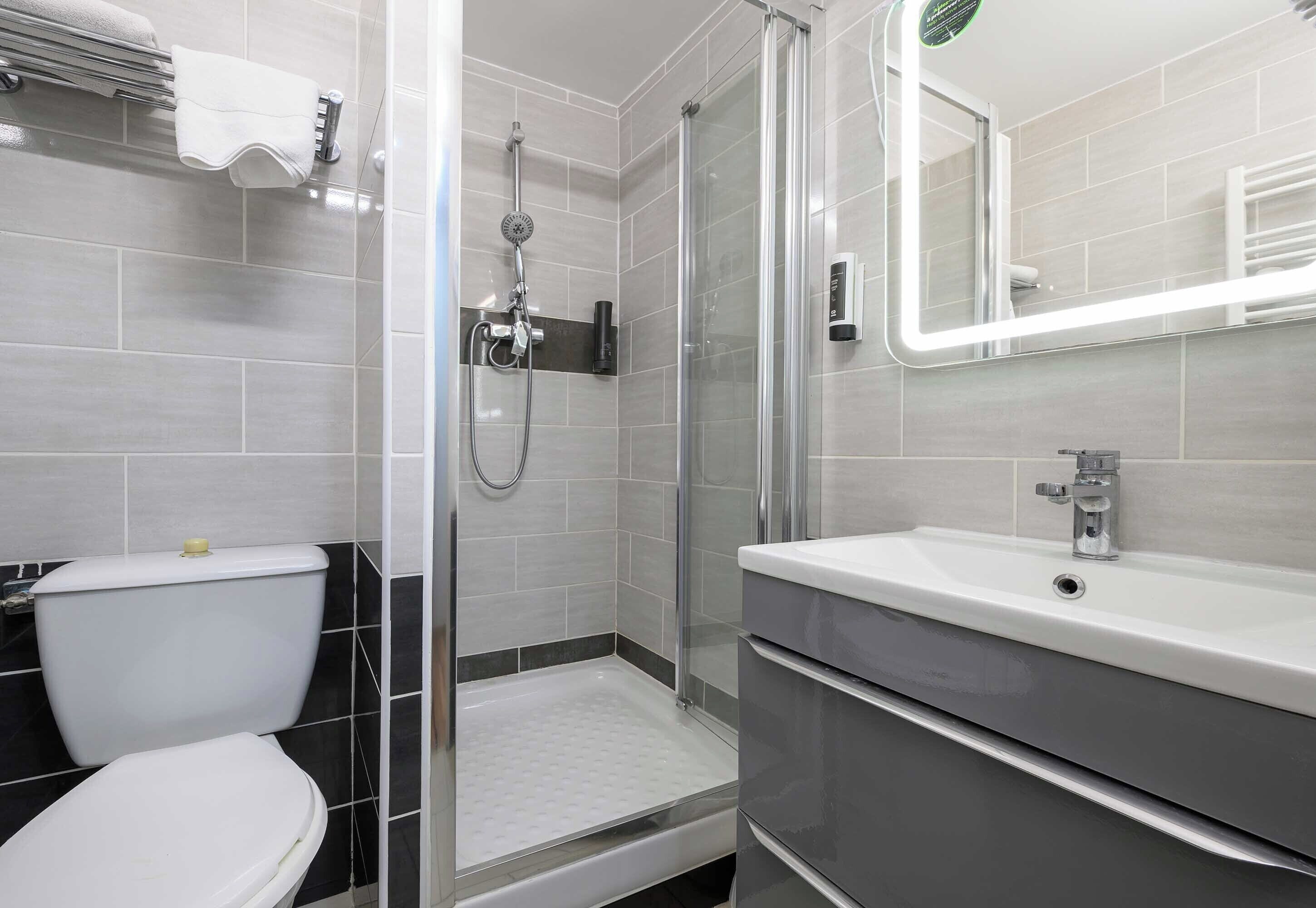 Une salle de bain moderne équipée d’une douche, de toilettes et d’un lavabo.