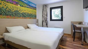 Une chambre d’hôtel avec un grand lit, un bureau et une fenêtre.