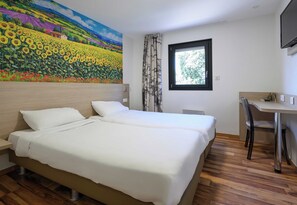 A hotel room with a large bed, a desk, and a window. - B&B HOTEL BOLLENE (Bollene)