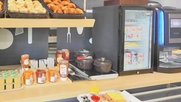 A breakfast buffet with various food items, condiments, and a coffee machine.