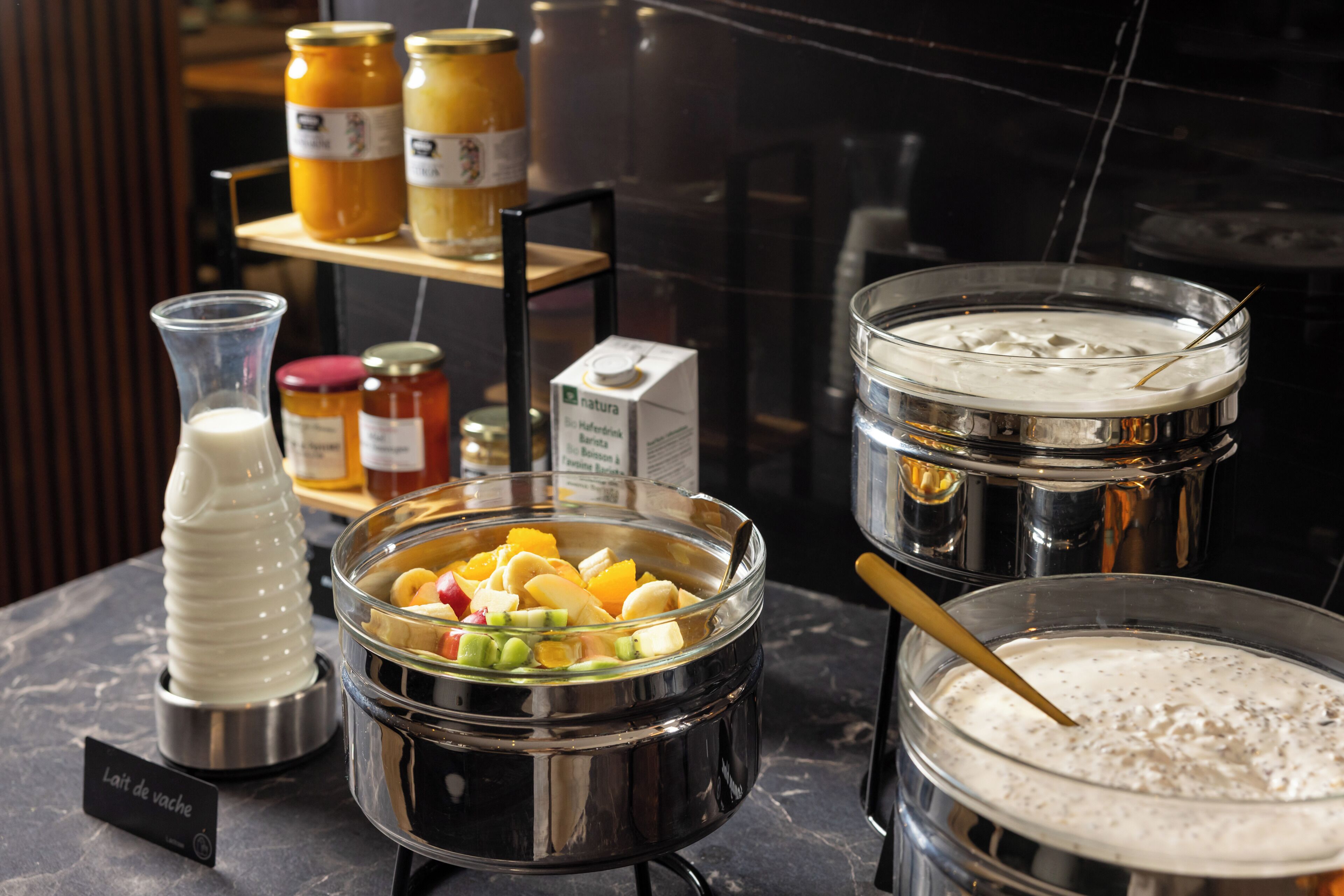 A buffet setup with various food items and condiments.