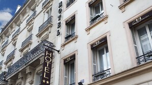 A hotel facade with balconies, a sign reading "HOTEL," and the name "Saint Martin" on the windows. - Garden Saint Martin (Paris)