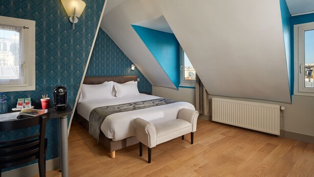 A bedroom with a bed, a desk, a chair, a radiator, and a window. - Garden Saint Martin (Paris)