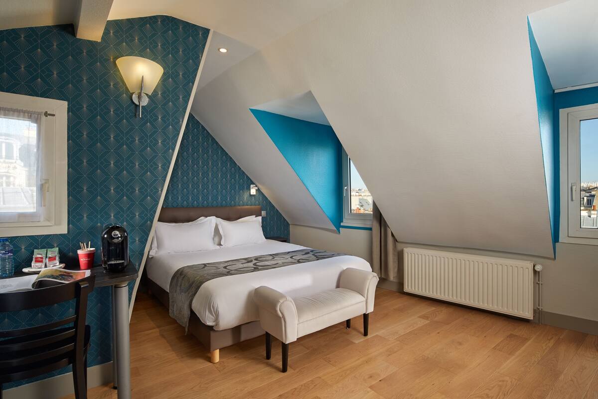 Ein Schlafzimmer mit einem Bett, einem Schreibtisch, einem Stuhl, einer Heizung und einem Fenster.
