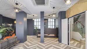 Een modern interieur met een visgraatvloer, moderne verlichtingsarmaturen en een receptiegedeelte met een trap.