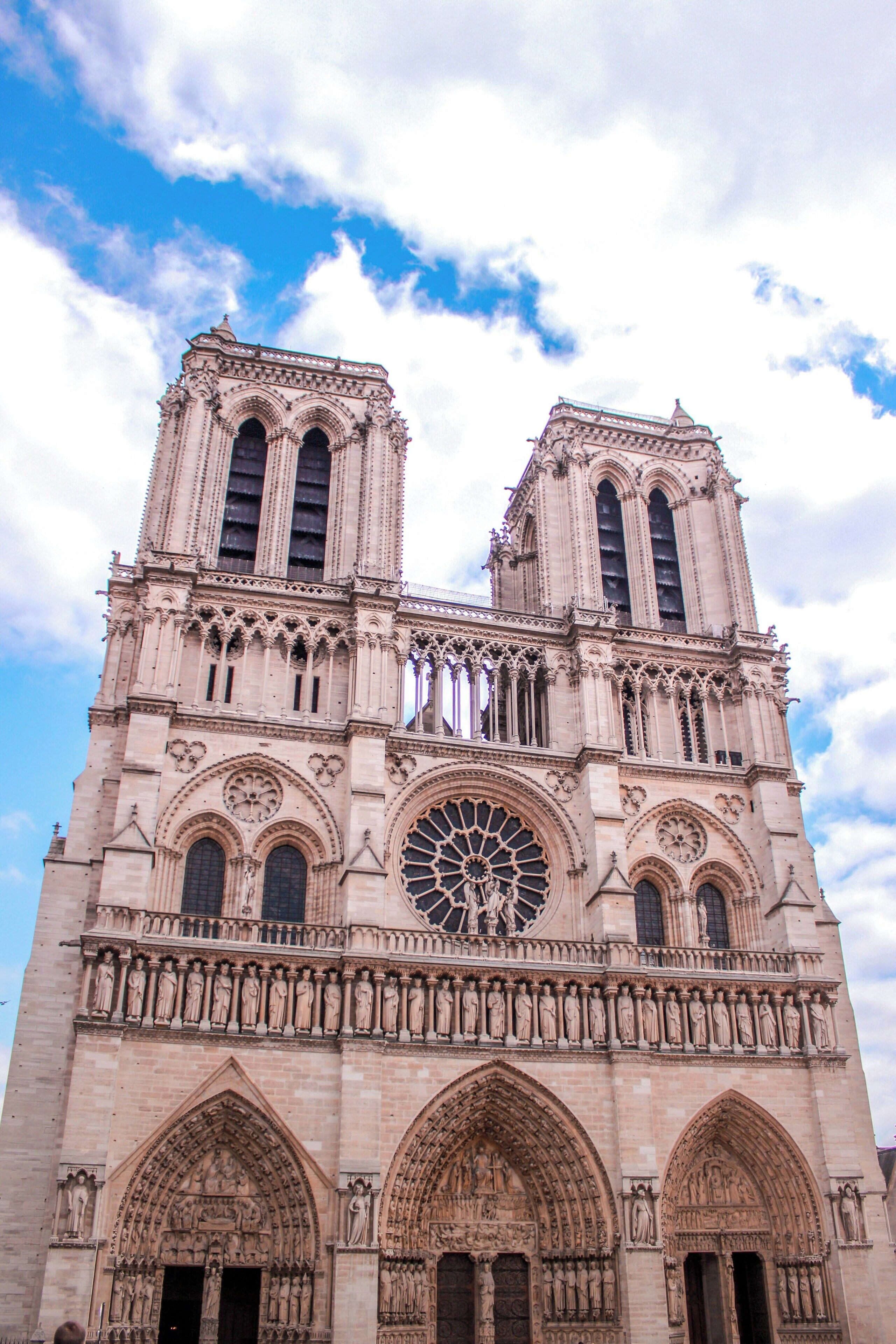 A large cathedral with two towers, intricate stone carvings, and a large rose window.