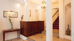 A grand lobby with a wooden reception desk, a staircase, and a chandelier. - Hotel Impérial Paris (Paris)