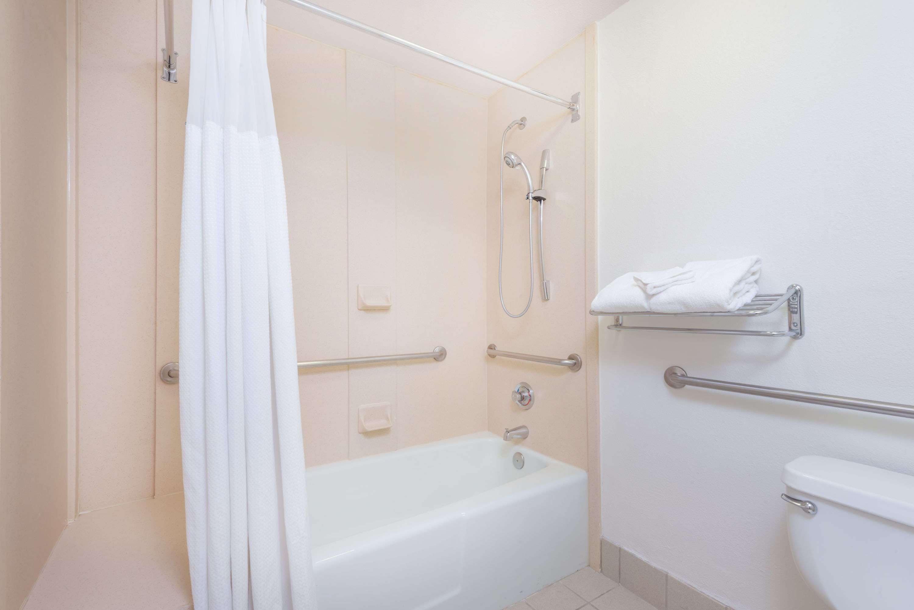 A bathroom with a bathtub, shower, and toilet.