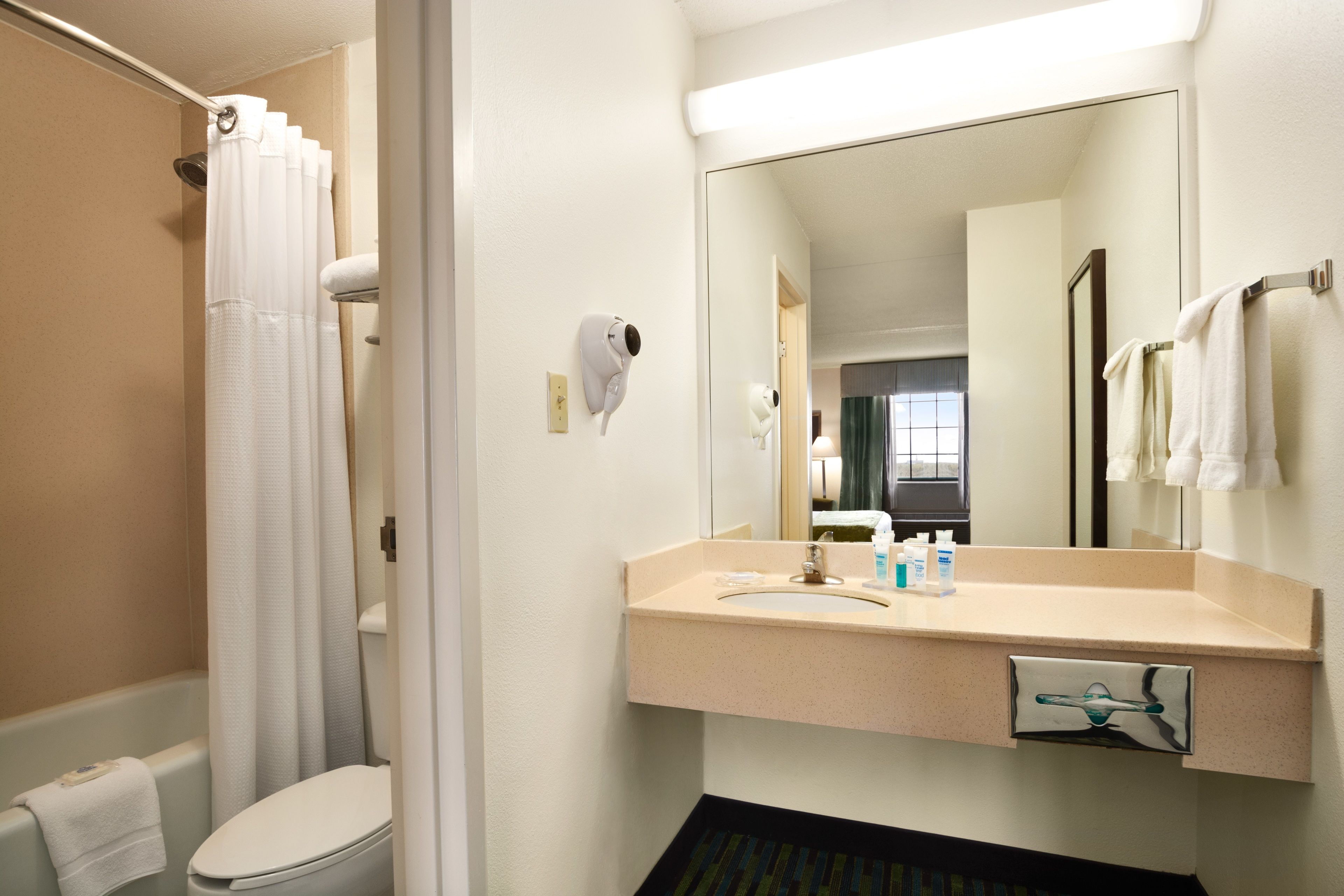 A bathroom with a toilet, sink, and shower curtain.