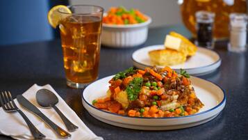A plate of food with a glass of tea and a pitcher in the background.