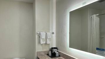 A bathroom with a toilet, sink, and mirror.