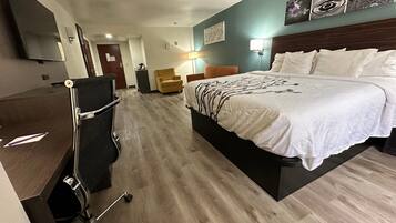 Una habitación de hotel con una cama, un escritorio, una silla y un televisor.