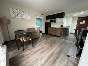A modern apartment with a dining area, kitchenette, and a living space.
