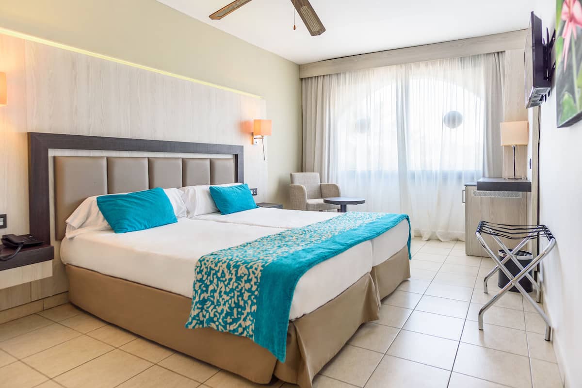 Een hotelkamer met een groot bed, een bureau, een stoel en een televisie.
