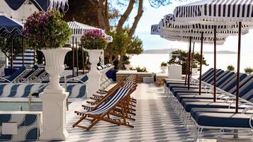 Piscine extérieure, parasols de plage, chaises longues