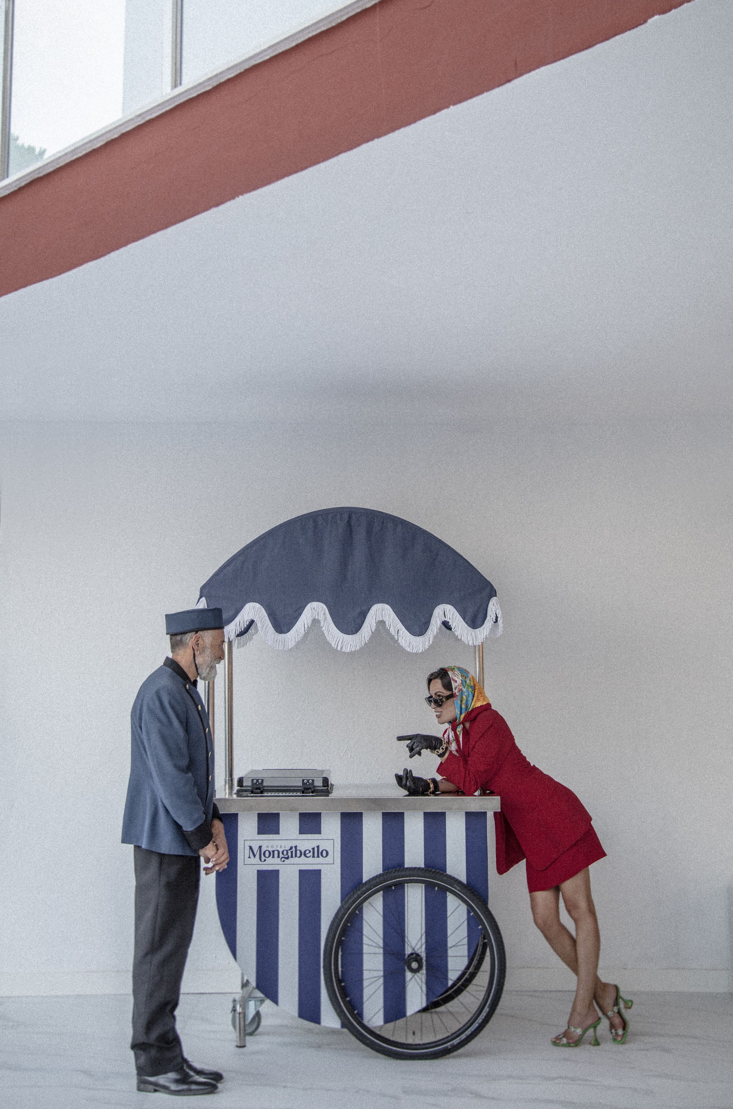 Un homme et une femme se tiennent devant un stand de nourriture sur lequel est affiché un panneau indiquant « Mongibello ».