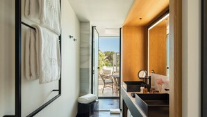 A modern bathroom with a large mirror, a sink, and a towel rack. - BLESS Ibiza Cala Nova - The Leading Hotels of the World (Santa Eulalia del Rio)