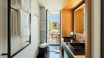 Un baño moderno con un espejo grande, un lavamanos y un perchero para toallas.