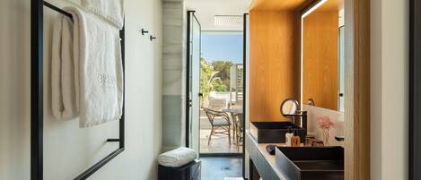 A modern bathroom with a large mirror, a sink, and a towel rack.