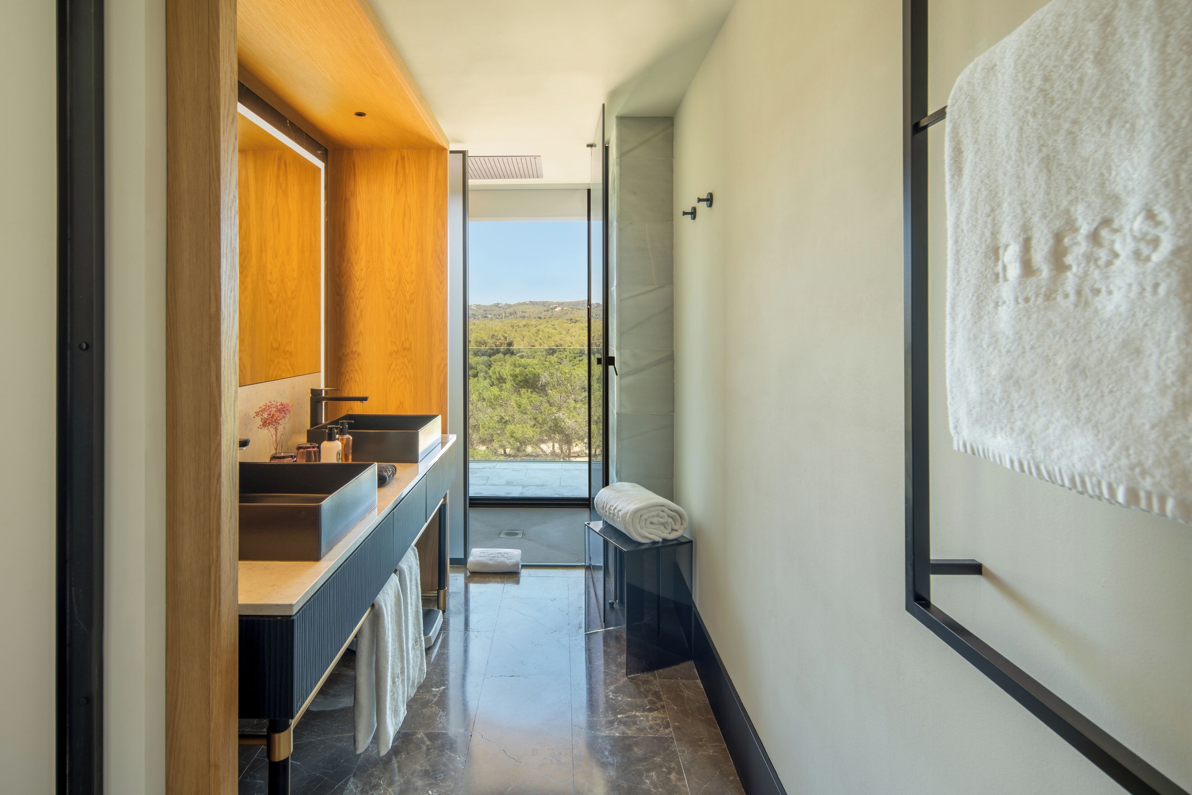 Une salle de bain moderne avec une grande fenêtre, un lavabo et un porte-serviettes.