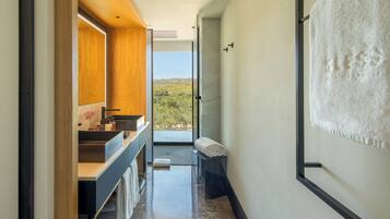 Une salle de bain moderne avec une grande fenêtre, un lavabo et un porte-serviettes.