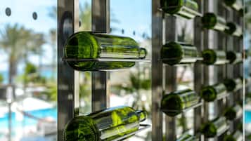 A wall of empty green glass bottles arranged in a grid pattern.