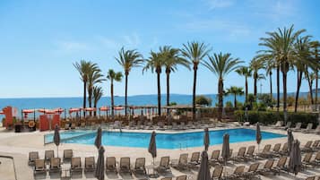Piscine extérieure, parasols de plage, chaises longues