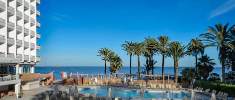 Een buitenzwembad, parasols voor strand/zwembad