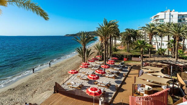 A beachside resort with sun loungers and umbrellas, a pool area, and a view of the sea. - Hotel Vibra Algarb (Ibiza Town)