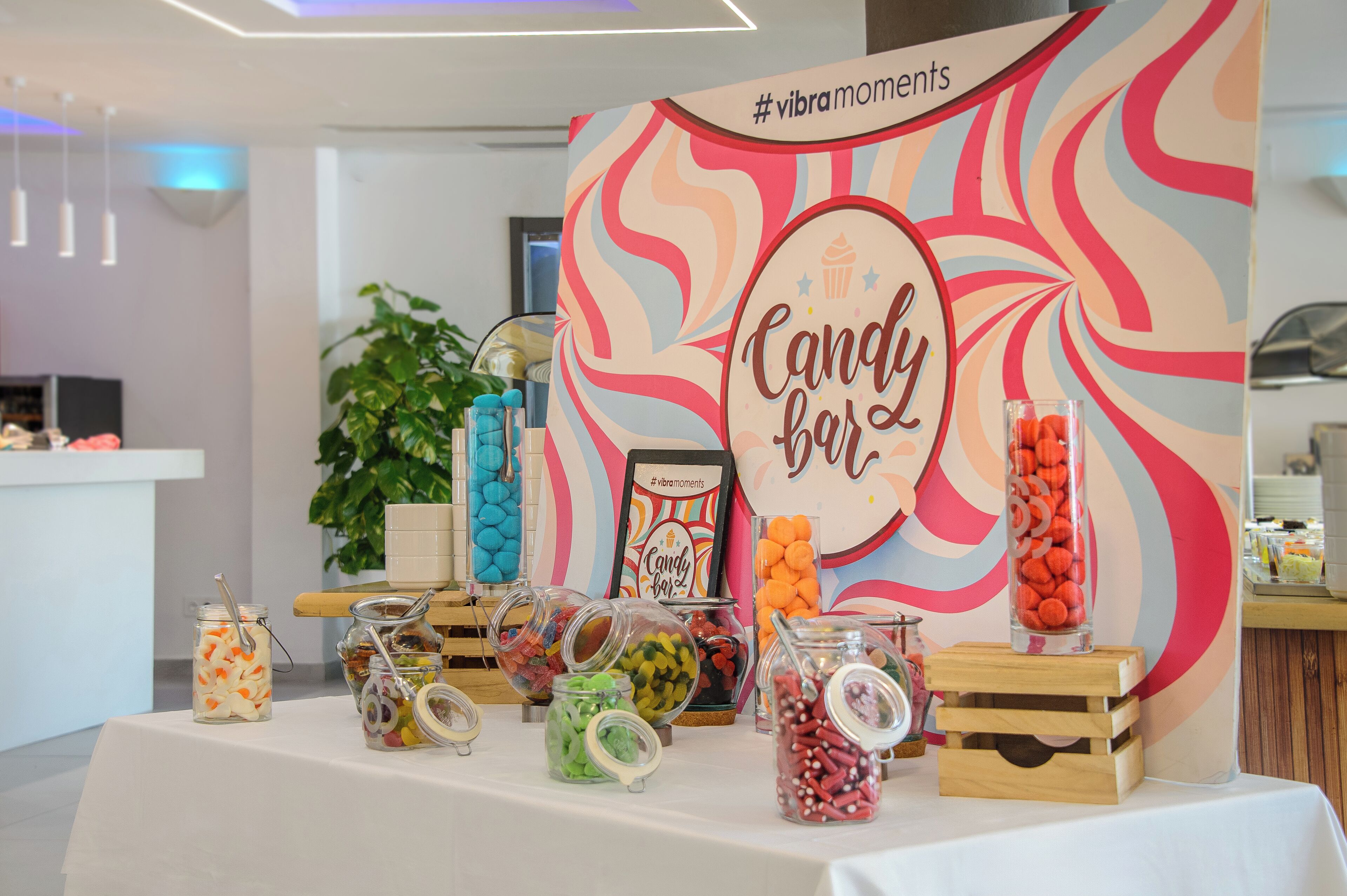 Un présentoir rempli de barres chocolatées de différentes couleurs, avec une pancarte indiquant « Barres chocolatées » et un hashtag.