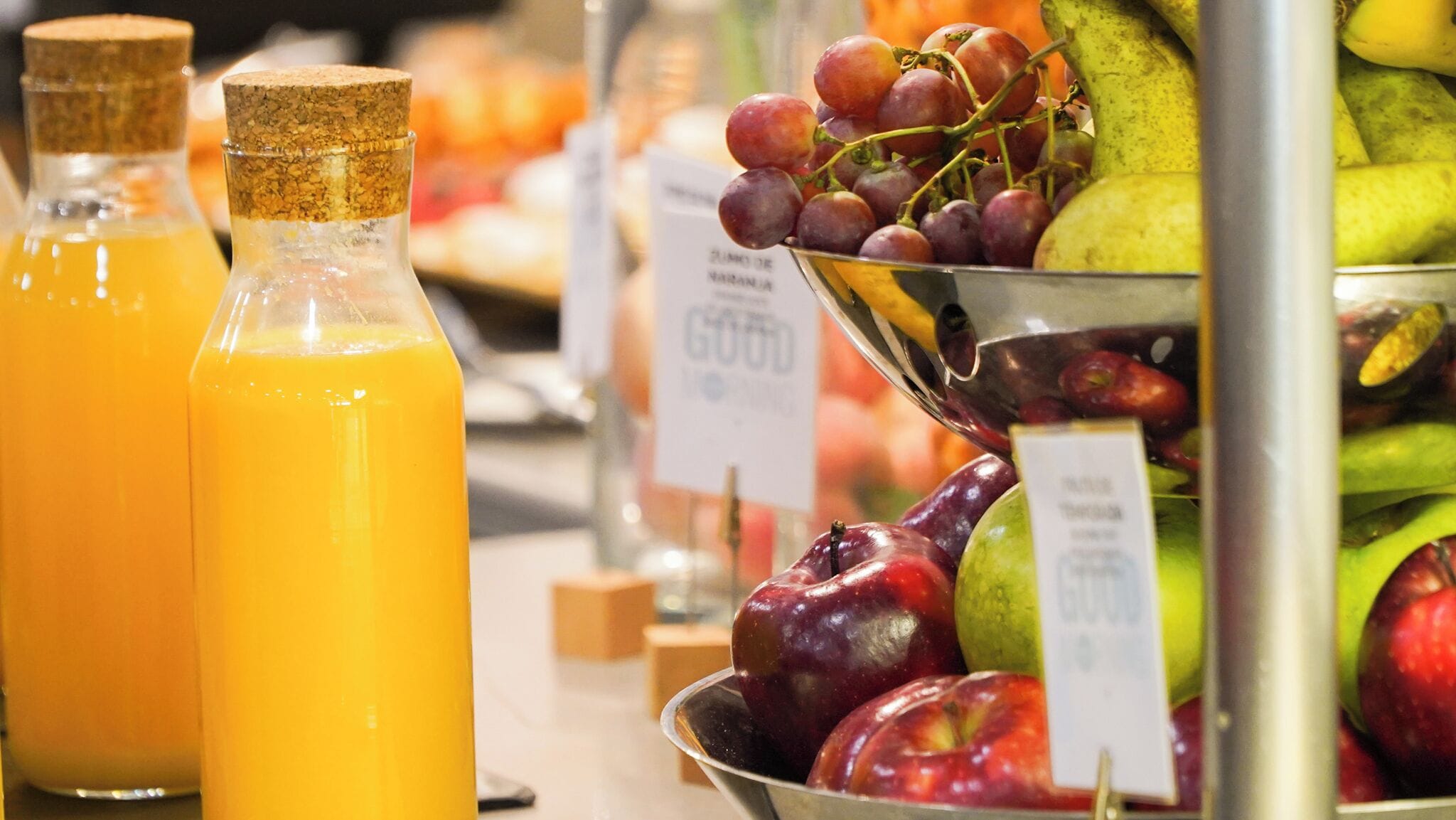 A display of fresh fruits and bottled orange juice in a store.
