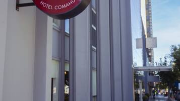 A sign for "Café - Resto Viento Sur Hotel Comahue" on a building's exterior.