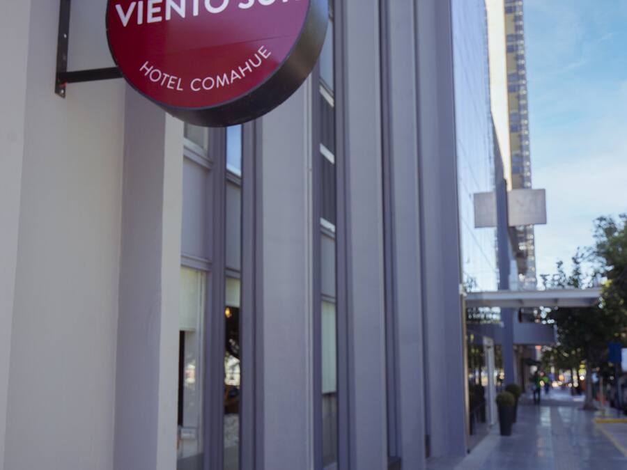 A sign for "Café - Resto Viento Sur Hotel Comahue" on a building's exterior.