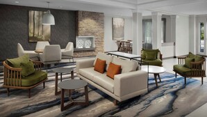 Ein modernes Wohnzimmer mit Sofa, Sesseln, einem Couchtisch und einem Essbereich.