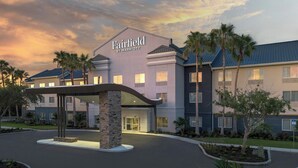Ein Hotel Fairfield by Marriott mit modernem Design, das einen markanten Eingangsbereich und eine gepflegte Außenanlage zeigt.