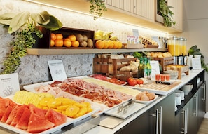 A buffet with various food items including fruits, cheeses, meats, and bread. - Hotel Sercotel AB Rivas (Rivas-Vaciamadrid)