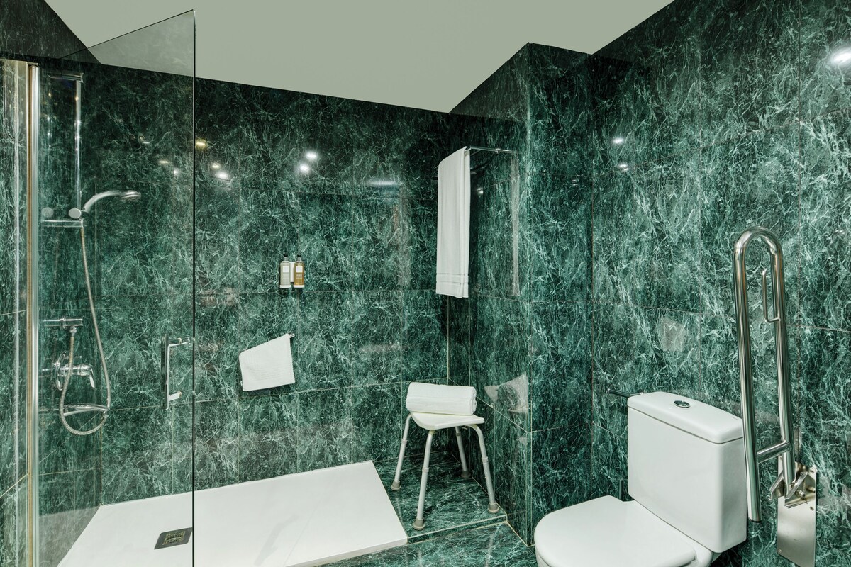 A modern bathroom with a glass-enclosed shower, a white toilet, and a white sink.