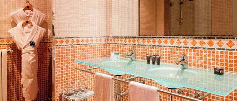 Un baño con un lavabo de vidrio, paredes de azulejos naranjas y un perchero para abrigos.