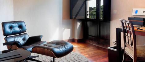 Una sala de estar moderna con un sofá de cuero, una mesa de centro redonda y una zona de comedor con una mesa y sillas de madera.