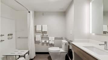 Ein modernes Badezimmer mit Toilette, Waschbecken und Dusche.
