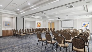 A conference room with rows of chairs, a projector screen, and a presentation screen. - Holiday Inn Express Hotel & Suites Vacaville by IHG (Vacaville)