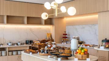 Un buffet proposant une variété de plats, un mur en marbre et un luminaire moderne.